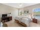 Bright bedroom with tile floors, two windows, and a desk at 12116 Stuart Dr, Venice, FL 34293