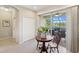 Bright breakfast nook with a small wooden table looking out to a screened in patio with a lake view at 12116 Stuart Dr, Venice, FL 34293