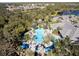 Aerial photo showcases the community pool, surrounded by mature trees and lounge seating at 12116 Stuart Dr, Venice, FL 34293