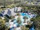 Aerial view of a resort-style pool with palm trees and a checkered sundeck in a lush community at 12116 Stuart Dr, Venice, FL 34293