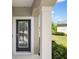 Elegant front door with decorative glass, complemented by a pillar and manicured landscaping at 12116 Stuart Dr, Venice, FL 34293
