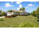 Beautifully landscaped front yard with palm trees and colorful flowerbeds at 12116 Stuart Dr, Venice, FL 34293