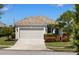Charming home with a two-car garage, tile roof, and colorful landscaping at 12116 Stuart Dr, Venice, FL 34293