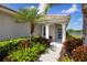 Inviting front porch with seating area surrounded by tropical landscaping at 12116 Stuart Dr, Venice, FL 34293