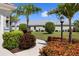 Lush landscaping and palm trees frame the front of this beautiful house at 12116 Stuart Dr, Venice, FL 34293