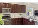 Kitchen with stainless steel appliances, modern countertops, and dark wood cabinets at 12116 Stuart Dr, Venice, FL 34293