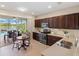 Well-equipped kitchen featuring dark wood cabinets, stainless appliances, and a view of the pool at 12116 Stuart Dr, Venice, FL 34293