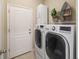 Laundry area featuring a washer, dryer, storage cabinet and nautical themed decor at 12116 Stuart Dr, Venice, FL 34293