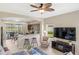 Comfortable living room with a ceiling fan, TV, and bar seating overlooking the lanai and lake at 12116 Stuart Dr, Venice, FL 34293