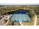 Birds eye view of a community pickleball court, lake, parking, and sidewalks at 12116 Stuart Dr, Venice, FL 34293