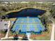 Aerial view of community pickleball courts next to a lake and parking area at 12116 Stuart Dr, Venice, FL 34293