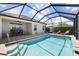 Spacious outdoor area featuring a screened-in pool, comfortable seating, and dining set with fan, perfect for entertaining at 12116 Stuart Dr, Venice, FL 34293
