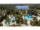 Overhead view of two pools with lounge chairs and sunshades, set among palm trees near a lake at 12116 Stuart Dr, Venice, FL 34293