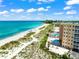 Beautiful aerial view of the beach with the condo pool and turquoise ocean waters at 1255 Tarpon Center Dr # 309, Venice, FL 34285