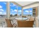 Enclosed lanai with glass table and chairs, with sweeping ocean views in the background at 1255 Tarpon Center Dr # 309, Venice, FL 34285