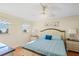 Bright bedroom featuring a light blue comforter, ceiling fan, and windows with ocean views at 1255 Tarpon Center Dr # 309, Venice, FL 34285
