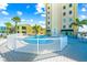 Community pool area featuring an outdoor pool, palm trees, and lounge chairs at 1255 Tarpon Center Dr # 309, Venice, FL 34285