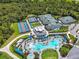 Aerial view of community pool, clubhouse, tennis and pickleball courts surrounded by green space at 12680 Radiance Ct # 12-101, Venice, FL 34293