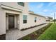 Exterior front entrance featuring fresh landscaping, brick paver walkway and a stylish front door at 12680 Radiance Ct # 12-101, Venice, FL 34293