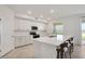 Bright kitchen featuring white cabinets, island with seating, and modern fixtures at 12680 Radiance Ct # 12-101, Venice, FL 34293