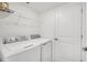 Laundry area contains new front load washer and dryer, overhead shelving, and access to the garage at 12680 Radiance Ct # 12-102, Venice, FL 34293