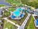 Aerial view of a luxurious pool area with tropical landscaping and lounge seating at 12680 Radiance Ct # 12-101, Venice, FL 34293