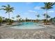 Beautiful community pool with surrounding palm trees and outdoor lounge chairs for residents at 12680 Radiance Ct # 12-101, Venice, FL 34293