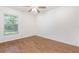 Bright bedroom features wood-look tile flooring, a window, a ceiling fan, and white walls at 1345 24Th St, Sarasota, FL 34234