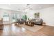 Bright living room with neutral decor, wood-look tile flooring, ceiling fan, and ample natural light from backyard access at 1345 24Th St, Sarasota, FL 34234