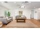 Inviting living room with wood-look floors, comfortable seating, a ceiling fan, and a seamless transition to the kitchen at 1345 24Th St, Sarasota, FL 34234