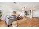 Bright and airy living room featuring wood-look flooring, neutral decor, ceiling fan, and convenient access to the kitchen at 1345 24Th St, Sarasota, FL 34234
