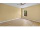 Bright bedroom features wood-look floors, yellow walls, and a window with a lush outdoor view at 1399 Shields St, Punta Gorda, FL 33980