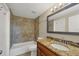 Granite countertops accent this bathroom with tiled shower and tub combination at 1533 Olympia Rd, Venice, FL 34293