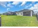 Spacious backyard featuring lush green grass, a screened-in porch, and a charming black fence at 16411 62Nd E Gln, Parrish, FL 34219