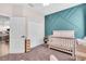 A cozy Bedroom features a white crib and an accent wall with geometric trim design at 16411 62Nd E Gln, Parrish, FL 34219