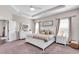 This bedroom has a tray ceiling, a large bed with neutral bedding, and two windows for natural light at 16411 62Nd E Gln, Parrish, FL 34219