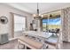 Dining area features a modern chandelier, a large table with bench seating, and a view of the screened lanai at 16411 62Nd E Gln, Parrish, FL 34219