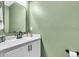 Charming half bath featuring an white vanity with marble countertop, black fixtures, and light green painted walls at 16411 62Nd E Gln, Parrish, FL 34219