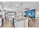 Modern open-concept kitchen with granite countertops, white cabinetry, and an island with bar seating at 16411 62Nd E Gln, Parrish, FL 34219