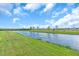 Picturesque view of a tranquil pond with lush greenery and clear blue skies above at 16411 62Nd E Gln, Parrish, FL 34219