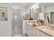 Bathroom features a double sink with granite countertop and glass-enclosed shower at 19801 Fishhawk Trl, Venice, FL 34293