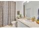 Bathroom with a vanity with granite countertop, a toilet, and a shower with a patterned curtain at 19801 Fishhawk Trl, Venice, FL 34293