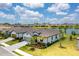 A single-Gathering home sits on a verdant lawn with views of a lake and beautiful landscaping around the property at 19801 Fishhawk Trl, Venice, FL 34293