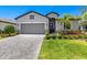 Beautiful single-Gathering home with a gray paver driveway and mature landscaping around the property at 19801 Fishhawk Trl, Venice, FL 34293