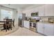 Modern kitchen features stainless steel appliances, granite countertops, and white cabinets at 19801 Fishhawk Trl, Venice, FL 34293