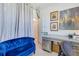 Comfortable home office with a blue sofa, a stylish desk and good lighting at 19801 Fishhawk Trl, Venice, FL 34293