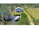 Beautiful aerial view of a modern blue house with a dock, boat, canal access and a lush green lawn at 217 22Nd Street Ne Ct, Bradenton, FL 34208