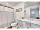 Charming bathroom features a toilet, sink, vanity, and a shower behind a curtain at 217 22Nd Street Ne Ct, Bradenton, FL 34208
