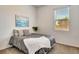 Cozy bedroom with neutral tones featuring a comfortable bed, modern art, and large windows at 217 22Nd Street Ne Ct, Bradenton, FL 34208