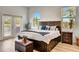 Bright main bedroom with light wood floors, stylish furniture, and a view to the exterior at 217 22Nd Street Ne Ct, Bradenton, FL 34208